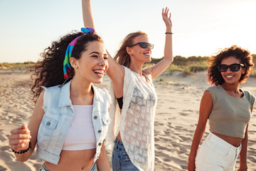 Three cheerful girls friends in summer clothes