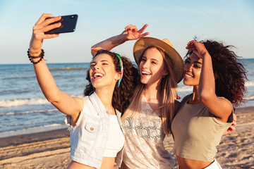 Three happy girls friends in summer clothes