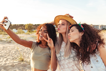 Three excited girls friends in summer clothes