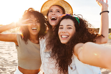 Fototapeta Three cheerful girls friends in summer clothes obraz