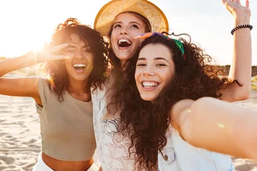 Fotobehang Three cheerful girls friends in summer clothes © Drobot Dean