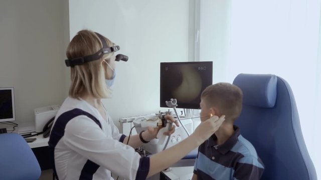 Doctor examine ear of little boy with ENT telescope
