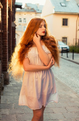 Obraz premium Attractive ginger girl with long hair wearing white transparent dress