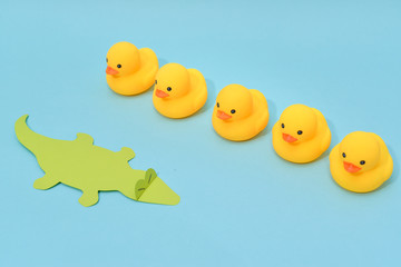 Challenge concept, rubber ducks are facing crocodile.