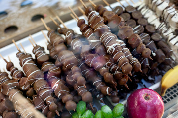 Different fruit sticks: Fresh strawberries,bananas covered with white and dark chocolate for sale on local market place in Vienna.
