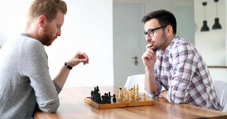 Portrait of two young man playing chess