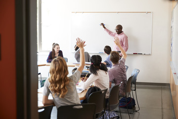 View Through Doorway Of High School Tutor At Whiteboard Teaching Class