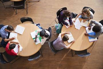 Overhead Shot Of High School Pupils In Group Study Around Tables - Powered by Adobe