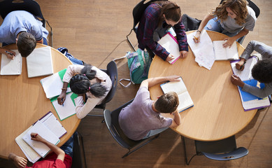 Overhead Shot Of High School Pupils In Group Study Around Tables
