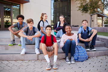 Portrait Of High School Student Group Sitting Outside College Buildings