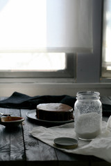 Chocolate cake, sugar jar, white curtain