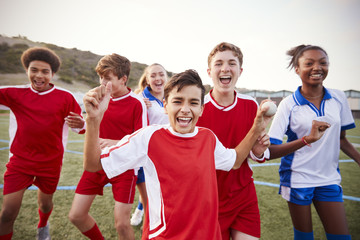 Portrait Of Male And Female High School Soccer Teams Celebrating