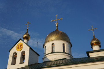Fototapeta na wymiar The orthodox church, Holy Trinity Cathedral in Kolpino, Russia. Gold domes with crosses and bells.
