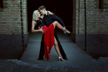 Young dancers perform Argentine tango. Dance of passion in the evening on a date a pair of lovers.