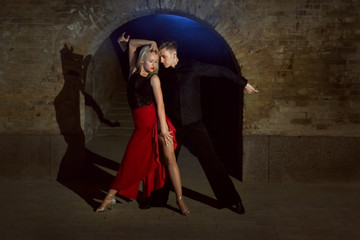Two young and beautiful dancers perform the tango. Latin American dances.