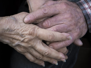 Elderly couple holding hands, expression of love and tenderness, close up