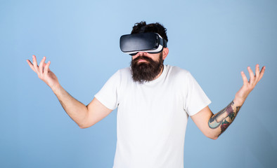 Man with hipster beard in idk posture isolated on blue background. Bearded software developer clueless about program bug in new VR equipment. Bearded man in virtual reality glasses testing new gadget
