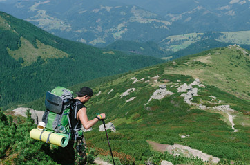 Happy hiker with a backpack on trekking in the hills