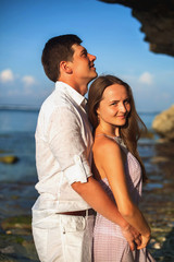 Portrait of happy couple, near the beach at background of sky.