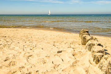 beach of Baltic Sea, Poland with groins and sail boat