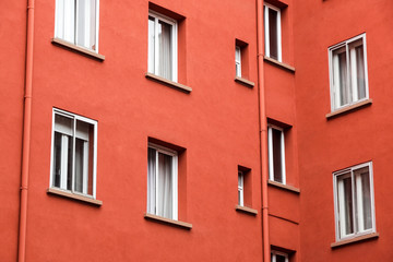 Fototapeta na wymiar Decorative white window on an old red urban wall .