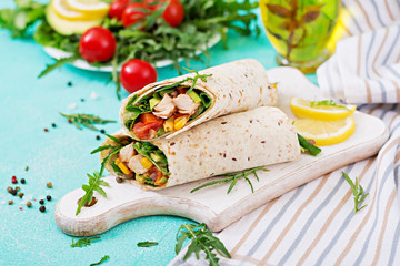 Burritos wraps with chicken and vegetables on light  background. Chicken burrito, mexican food.
