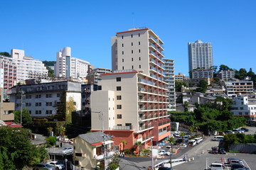 Fototapeta premium 熱海の海岸と丘陵に建つマンション 崖っぷちに立つ高層マンションが印象的だ