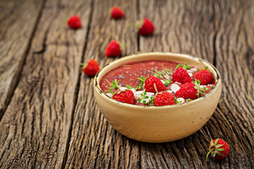 Detox and healthy superfoods breakfast in bowl. Vegan chia seeds pudding with strawberries and almond. Strawberries smoothie.