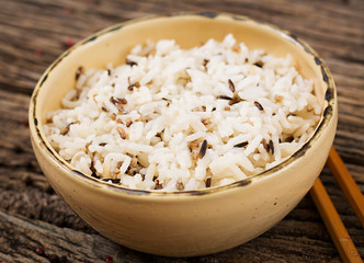Bowl with boiled rice on a wooden background. Vegan food. Dietary meal