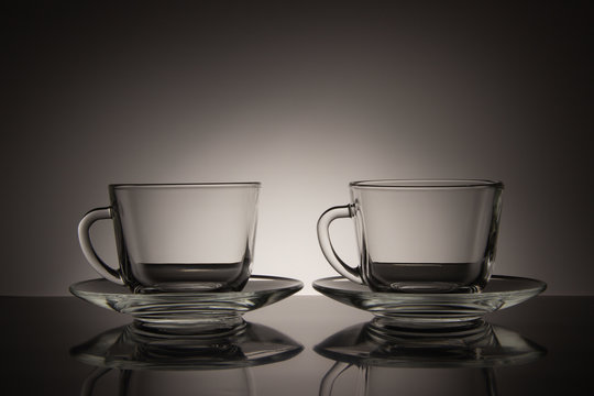 Two glass for tea and an empty saucer on a black and white background