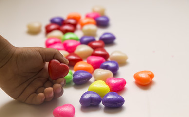 Valentines Day Concept: child holding heart .candy feast