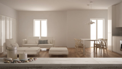 Wooden vintage table top or shelf with candles and pebbles, zen mood, over blurred minimalist living room with kitchen and dining table, white architecture interior design