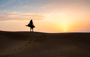 Woman in the desert with sunset view