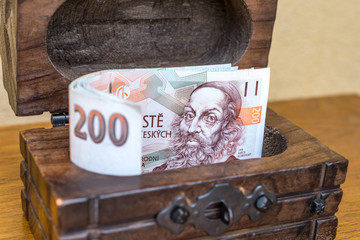 Czech 200 koruna banknotes folded in a vintage wooden box. Concept of personal reserves kept in cash at home and collecting for retirement