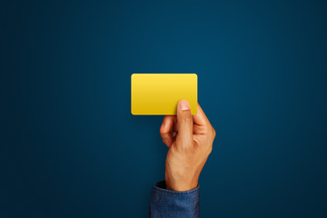 Businessman holding golden business card on blue background. Business branding. Service rating, satisfaction concept
