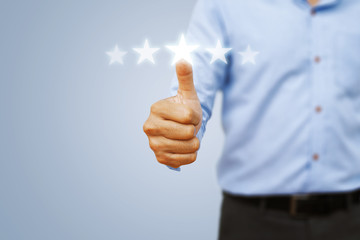 Hand of client show a excellent services rating by thumb with giving five star rating. Service rating, satisfaction, customer experience concept