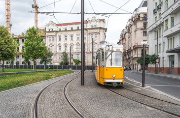 Naklejka premium Yellow tram on line 2 approaching Parliament square. Line 2 of Budapest is deemed to be one of the most beautiful tram lines in the world.