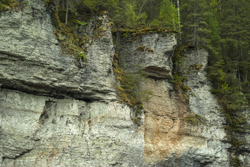 wooded limestone rocky cliffs with a figure resembling an ugly face