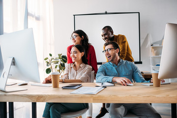 smiling multiracial business team working on project together in office