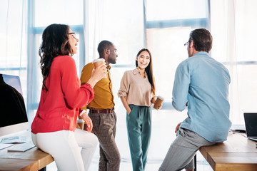 Obraz premium interracial business colleagues having conversation during coffee break in office