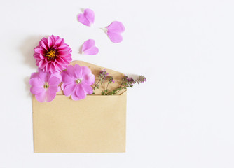 Brown envelope with a spring flower arrangement isolated on white background. Flat lay, top view. Empty space for your text.