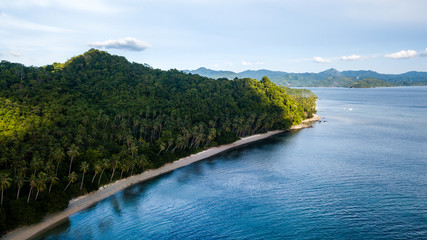 Fototapeta na wymiar Aerial drone view of a beautiful tropical bay with reef, sandy beach and jungle scenery