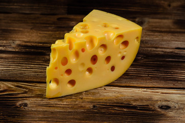 Piece of cheese on wooden table