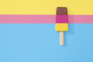 Ice cream popsicle lollipop on three pastel color background.  Wooden ice cream lolly toy