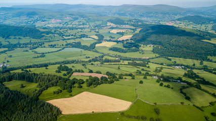 Aerial drone view of rural Wales showing farmed fields and green rolling hills