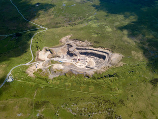 Aerial drone view of an old quarry scarring the otherwise green landscape in the Brecon Beacons...