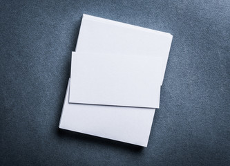 Stack of blank white business card on grey textured background top view. Identify design, corporate...