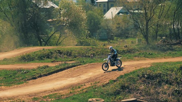 Racer is jumping over hills on his motorcycle 