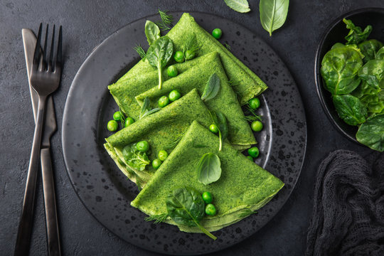 Spinach Crepes With Green Peas On Black Plate