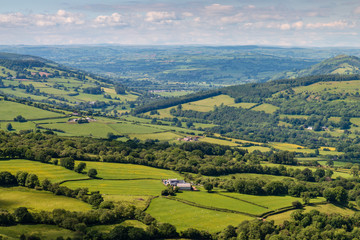 Obraz premium Aerial view of green farmland and fields in the rural Welsh countryside